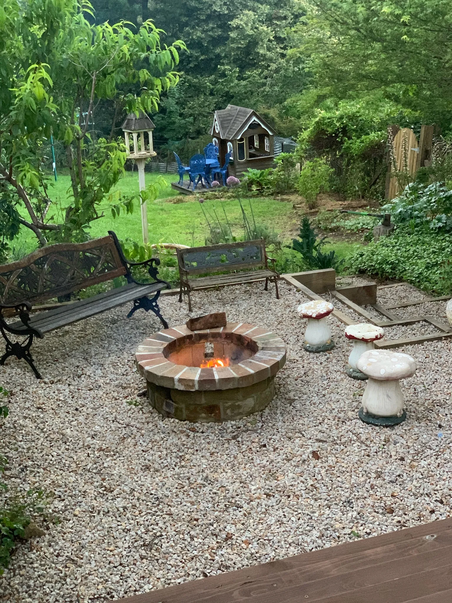 Garden fire pit with toadstool seats and the children's cubby house