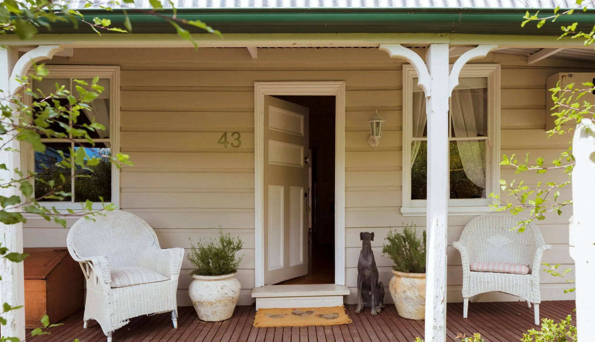 Front verandah of Illalangi with the door open and greyhound statue at the entry